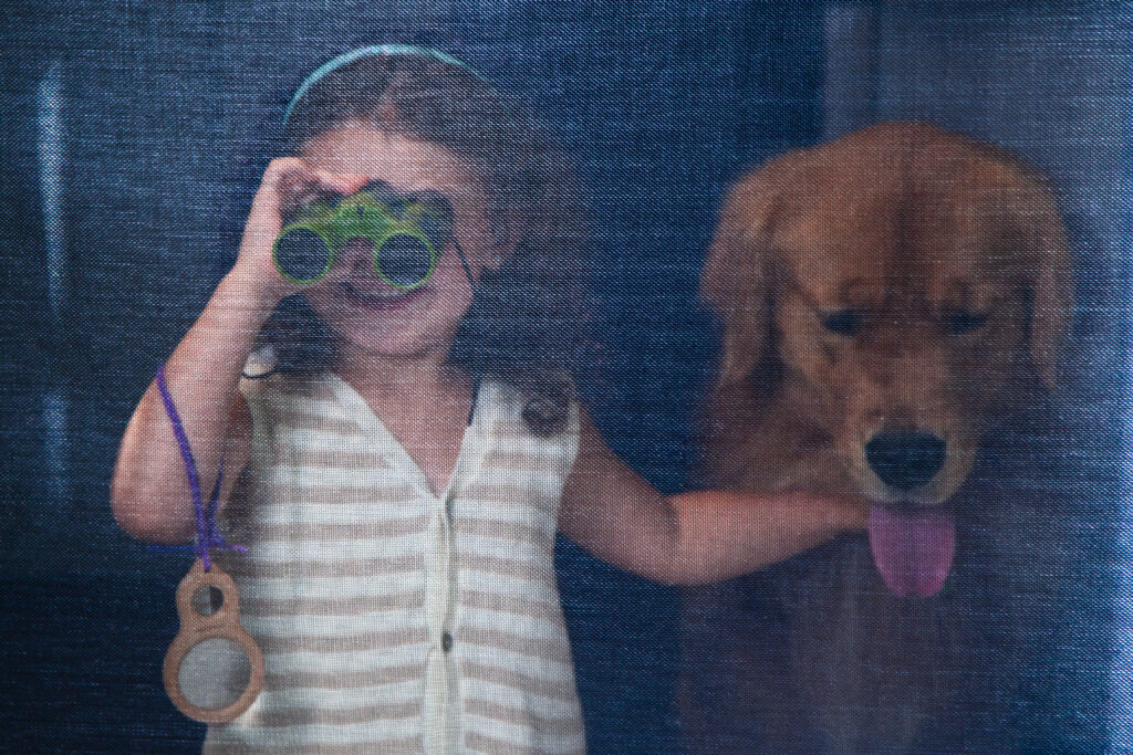 Girl with binoculars and a dog behind a 17504 mesh retained screen